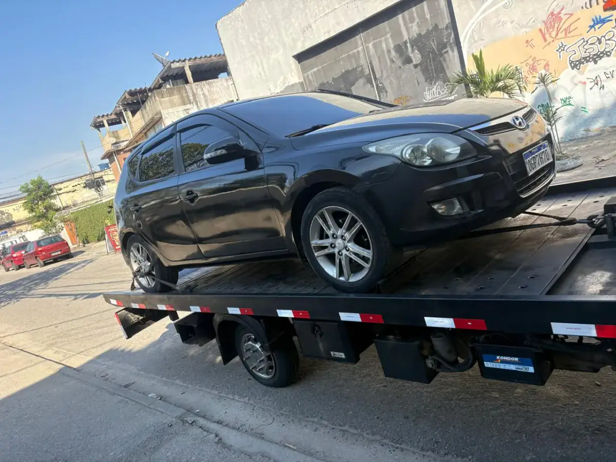 Hyundai i30 preto amarrado na plataforma de reboque