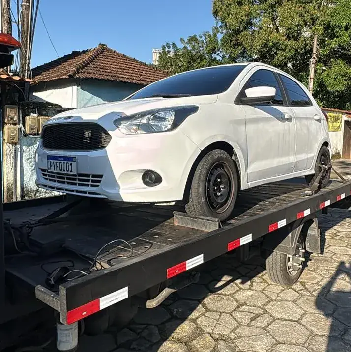Ford Ka branco com farol danificado na plataforma
